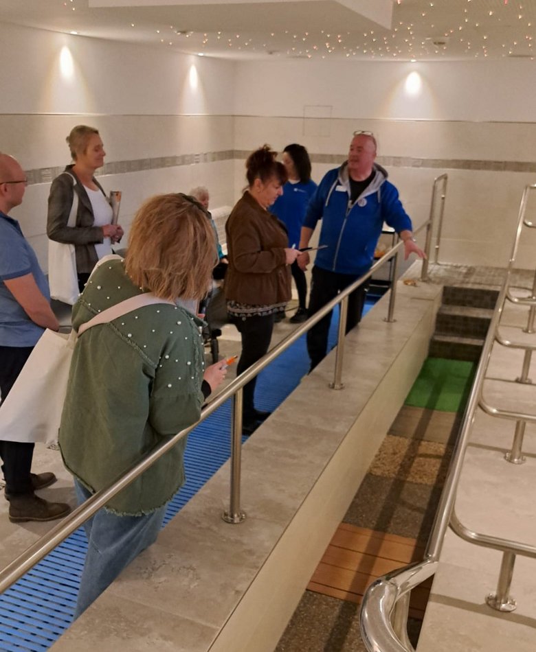 Eine kleine Gruppe schauen sich das Wassertretbecken an.