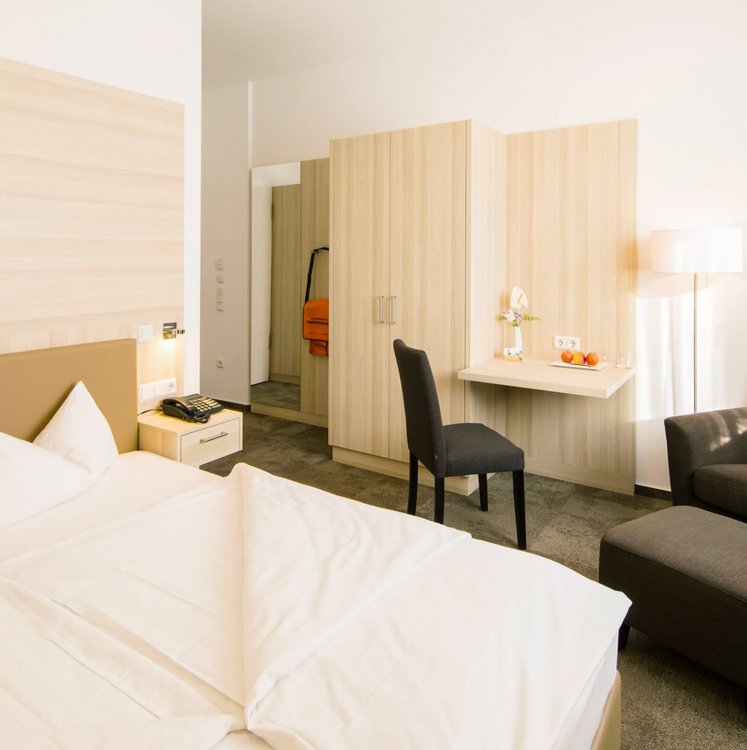 Zimmer mit Doppelbett, Sessel und Schrank