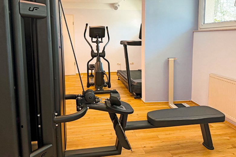 Fitnessraum mit Crosstrainer und 4-Stationen-Kraftturm